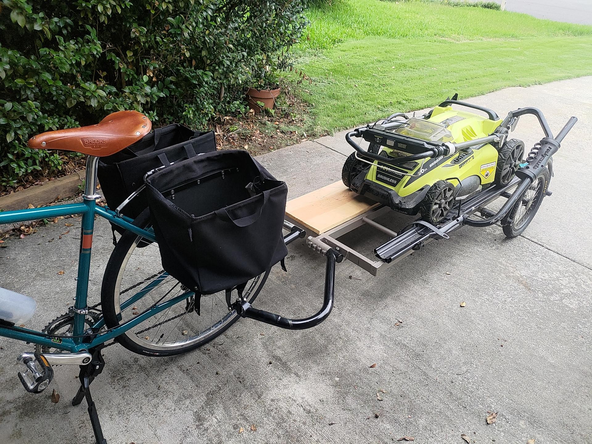 A lawn mower on a bicycle trailer.