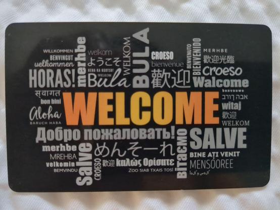 Welcome card at a hotel that has "Welcome" in many languages, including Okinawan in Japanese phonetic script.