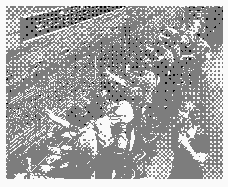 An old photograph of people working at a switchboard. The image is dithered and monocolor.