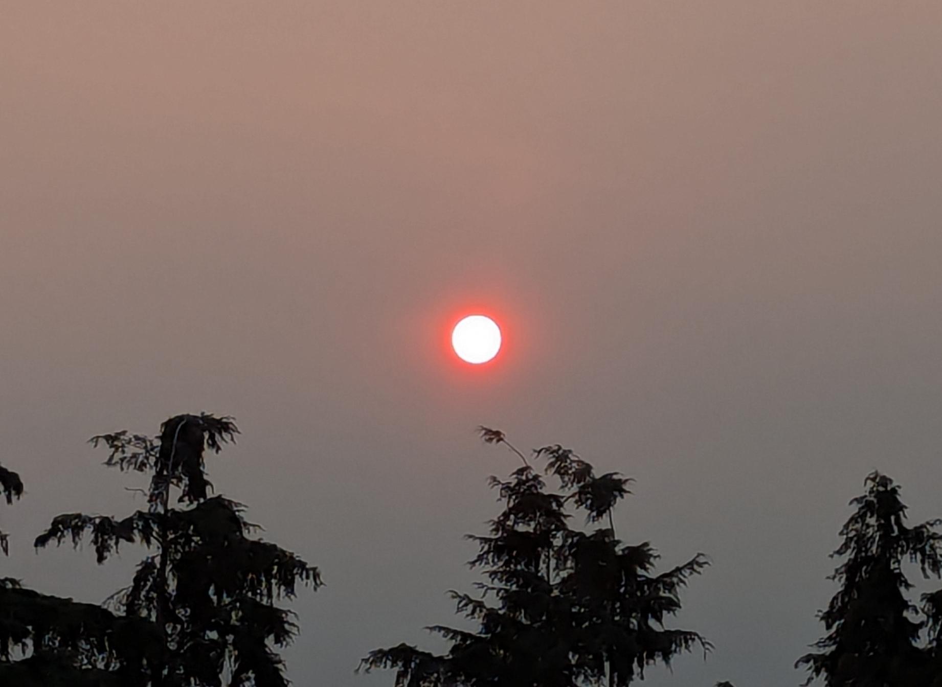 an orange sun in an orange to gray sky